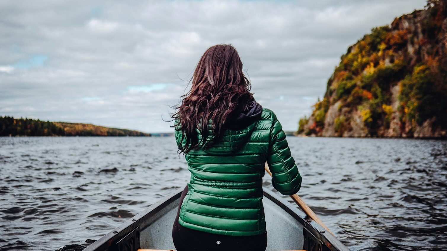 woman sitting on boat on lake