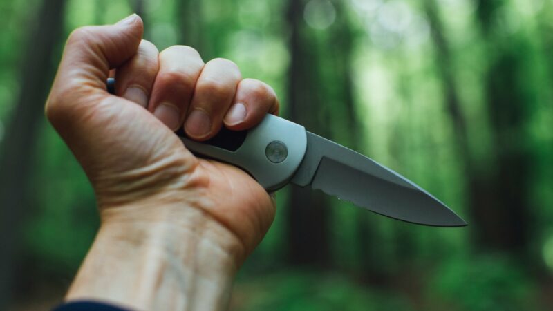 person holding gray and black knife