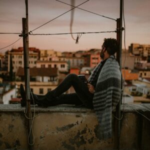 man in black and white stripe long sleeve shirt and black pants sitting on boat during