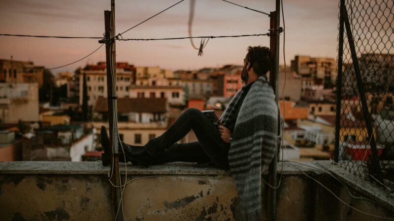 man in black and white stripe long sleeve shirt and black pants sitting on boat during