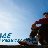 A man sitting on top of a cement wall